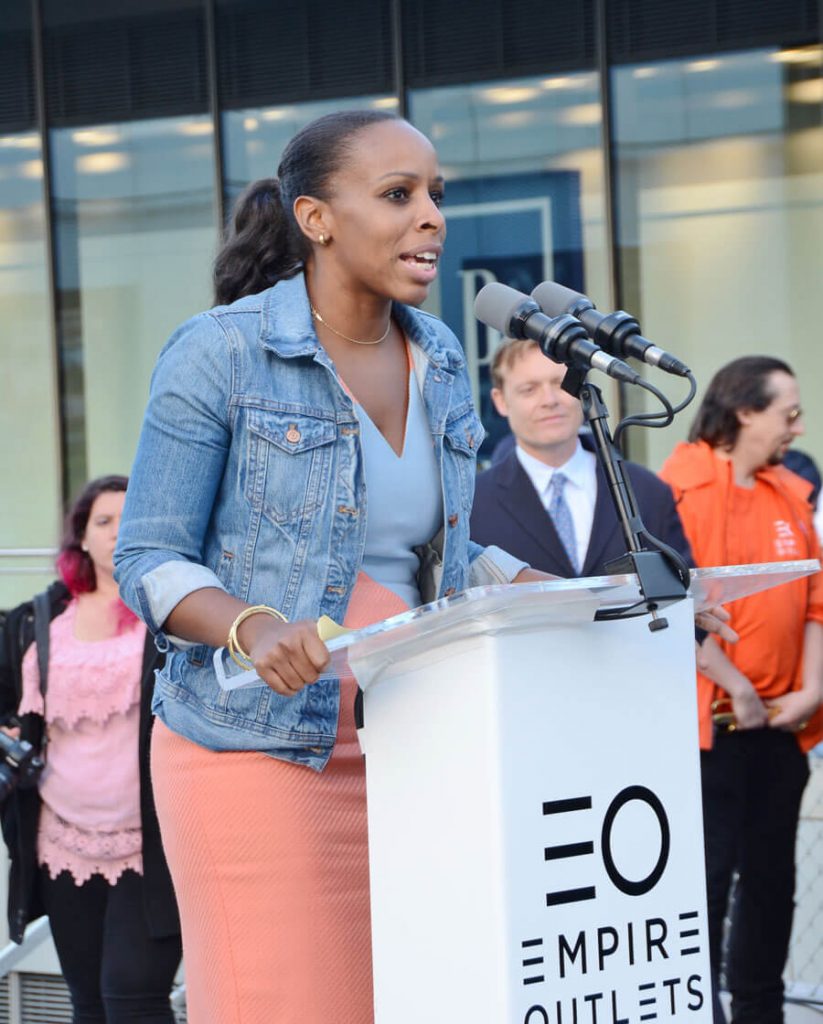 Woman speaks outside Empire Outlets